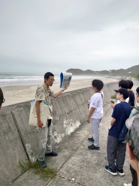 ＜写真⑪＞震災当日、私はここで津波被災に遭いました、説明を受ける