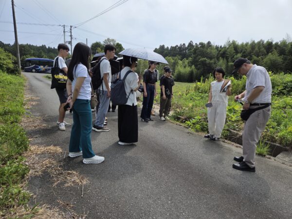 ＜写真4＞菅野さんの旧実家前で説明を受ける