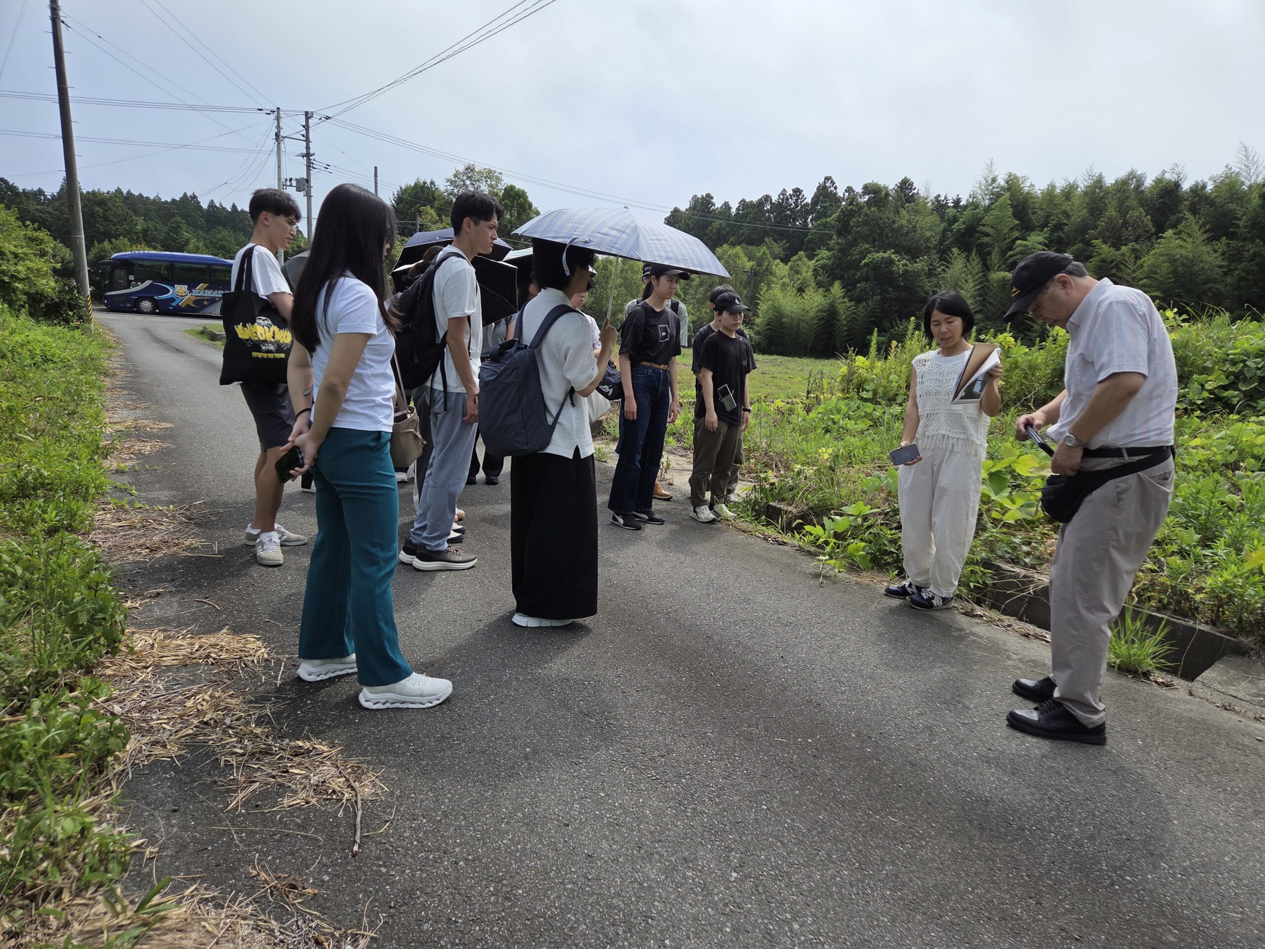 ＜写真4＞菅野さんの旧実家前で説明を受ける
